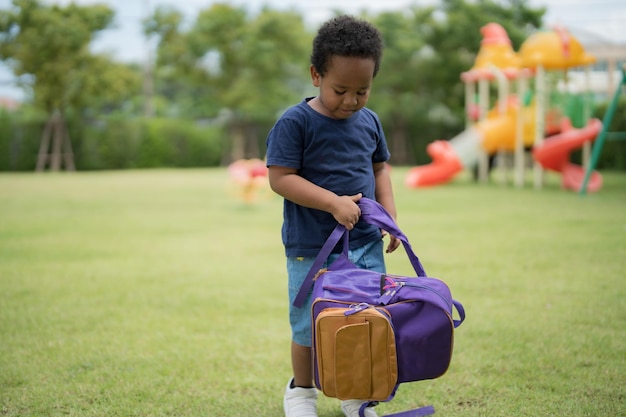 Cute little boy carrying a school bag with a smiling face