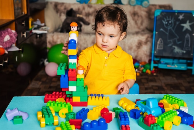 Cute little boy child playing at home with colorful cubes