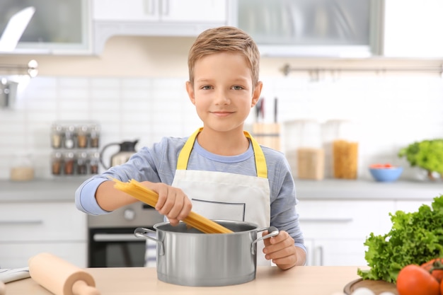 Cute little boy cooking in kitchen