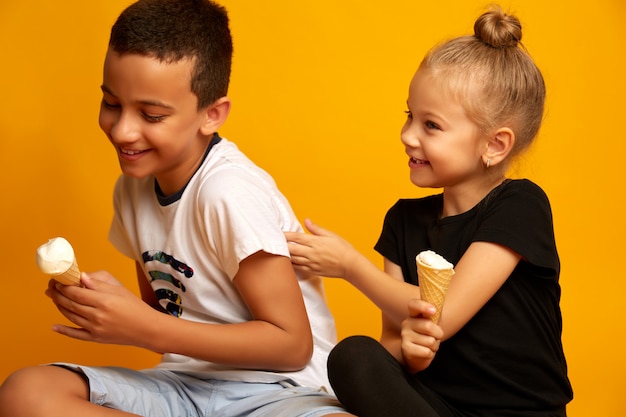 Cute little boy doesn't want to share ice cream with his sister