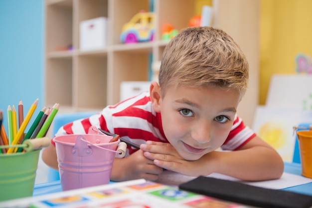 Cute little boy drawing at desk