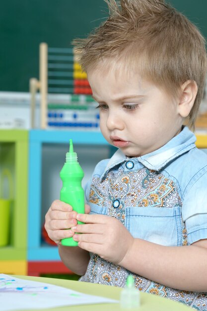 Cute little boy drawing at home or kindergarten