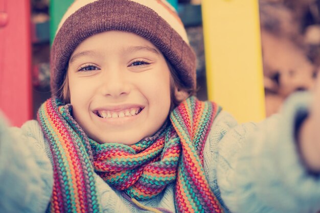 cute little boy having fun in playground park on cludy autum day