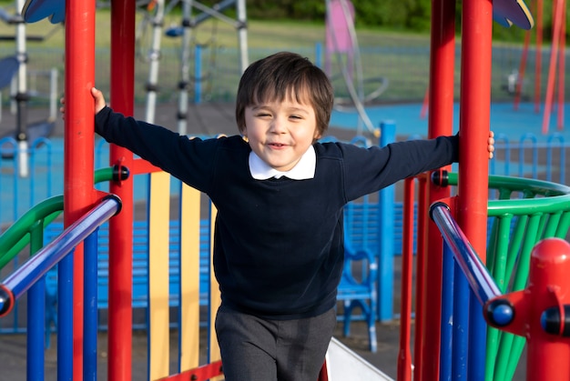 遊び場で楽しんでいるかわいい男の子