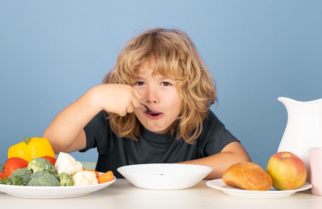 昼食にスープを食べるかわいい男の子 スープを食べる子供