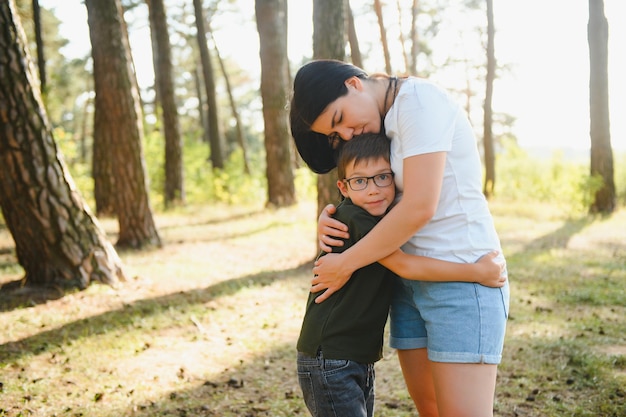 母親のかわいい男の子が自然の中を歩く