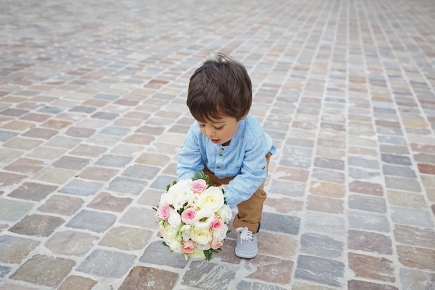 花の花束を持っているかわいい男の子