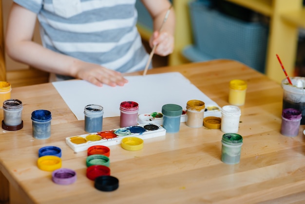 A cute little boy is playing and painting in his room. Recreation and entertainment. Stay at home.