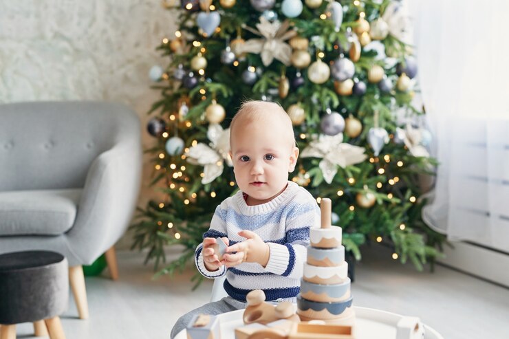 Cute little boy is playing with toy wooden train, toy car, pyramid and cubes, learning development concept. Development of kids fine motor skills, imagination and logical thinking