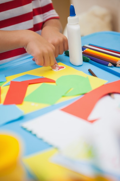 Cute little boy making art in classroom