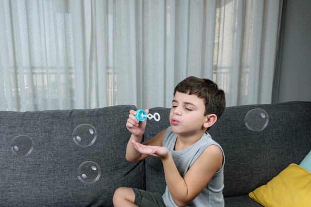 Cute little boy making soap bubbles