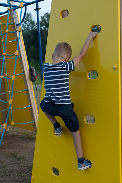 Ragazzino sveglio che gioca nel parco giochi