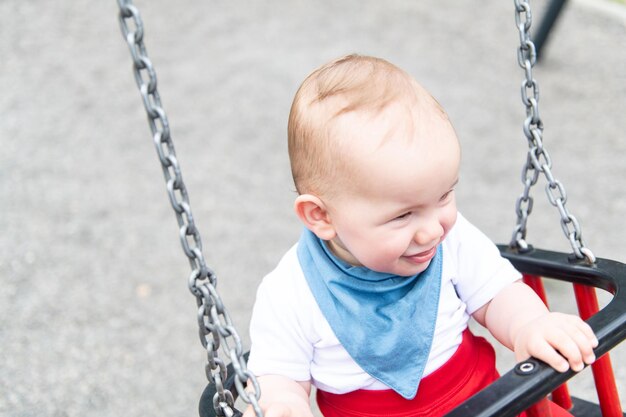 Cute Little Boy Playing on the Swings