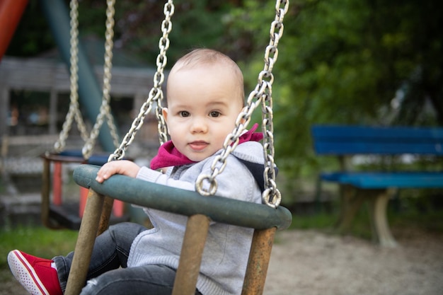 Cute Little Boy Playing on the Swings