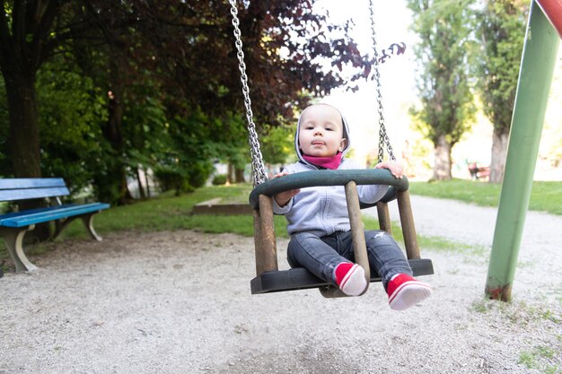 Cute Little Boy Playing on the Swings