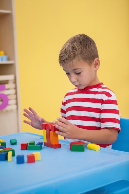 Cute little boy playing with building blocks