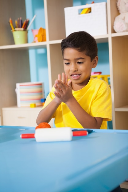 教室での粘土のモデリングで遊んでいるかわいい少年