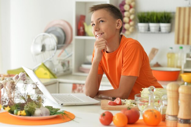 Photo cute little boy preparing salad