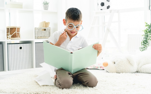 Cute little boy reading nice book