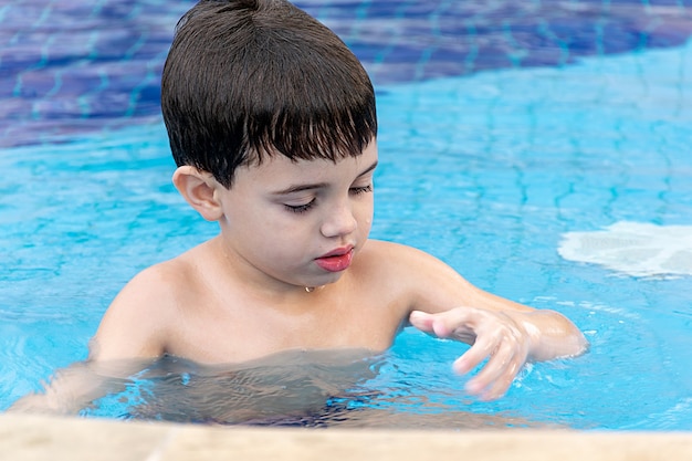 Cute little boy relaxing at the pool