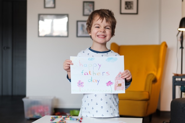 Cute little boy showing a drawing