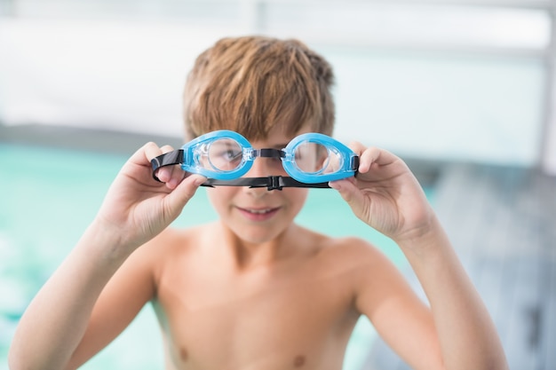 Cute little boy standing poolside