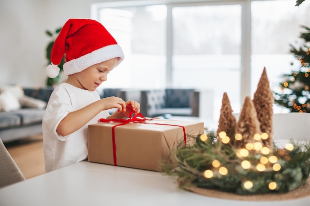 Cute little boy untying a bow on a gift box