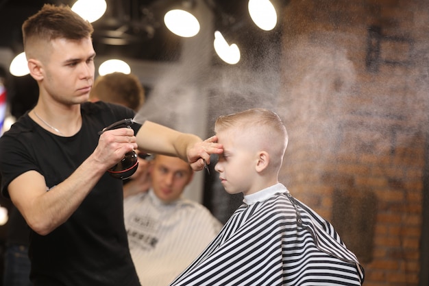 Cute little boy visiting a barbershop