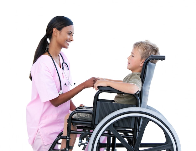 Симпатичный маленький мальчик в инвалидной коляске обсуждает с его врачом