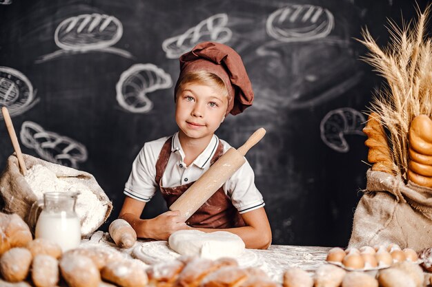 Photo cute little boy with chef hat cooking