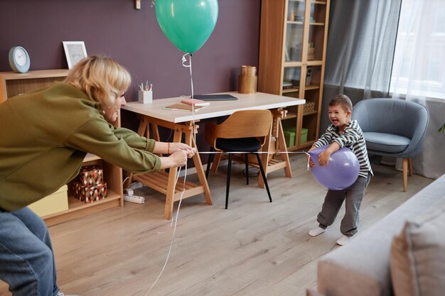 家で風船で遊ぶダウン症のかわいい男の子