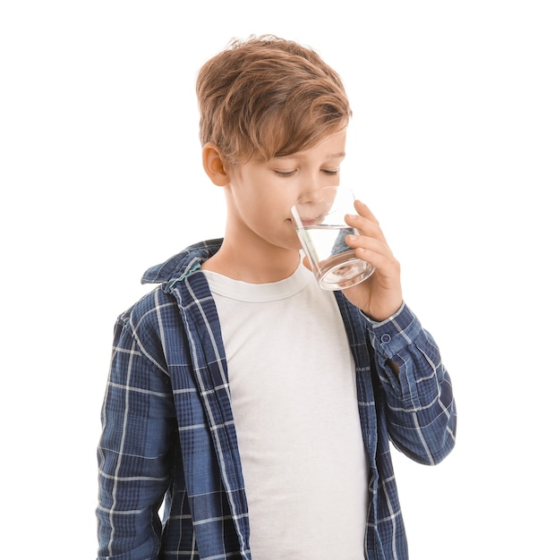 Cute little boy with glass of water on white