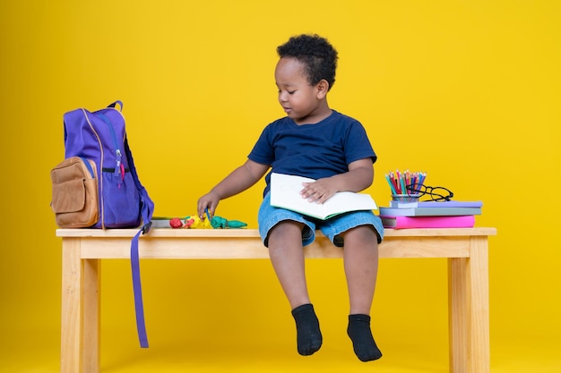 Cute little boy writing with a pencil in a notebook