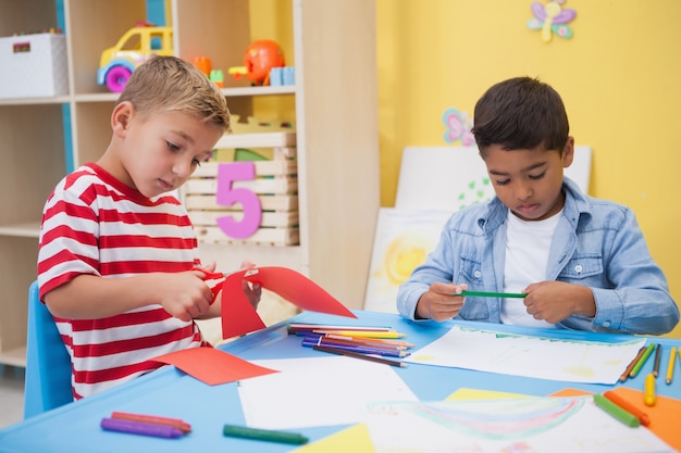 Cute little boys drawing at desk