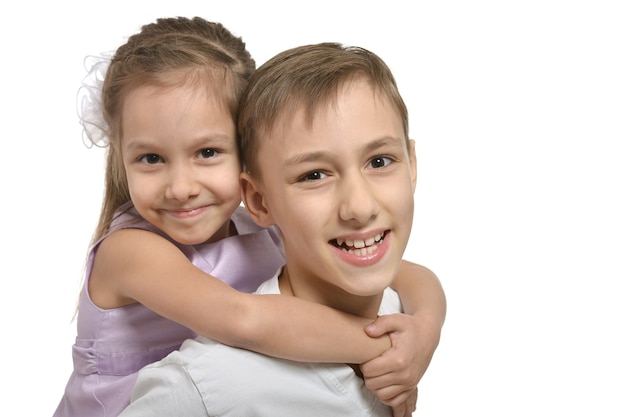 Cute little brother and sister hugging on white background