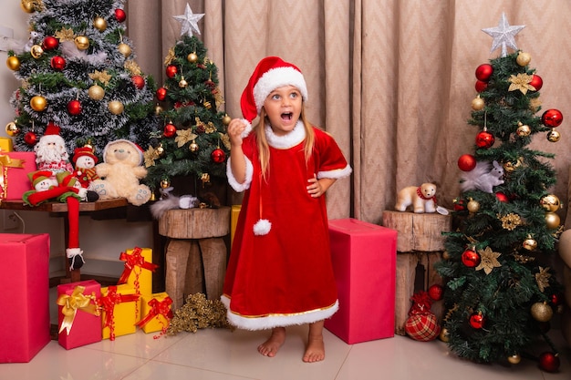 Cute little caucasian girl dressed for christmas at home. Girl on Christmas background dressed in noelete