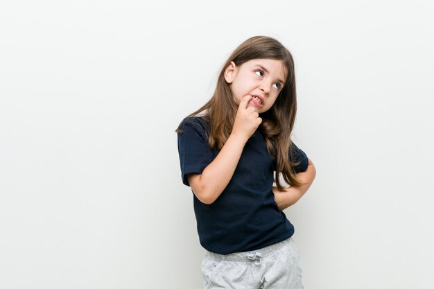 Cute little caucasian girl relaxed thinking about something looking at a copy space.