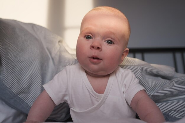 Cute little caucasian infant sitting on bed