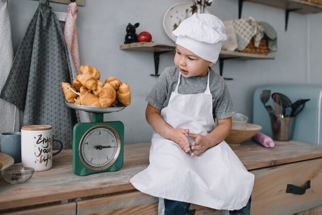 Photo cute little chef playing in the kitchen