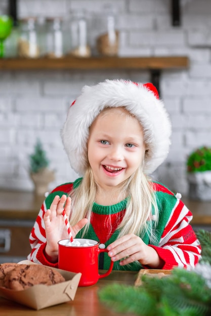 甘いクッキーを食べて、ホット チョコレートを飲むかわいい子女の子