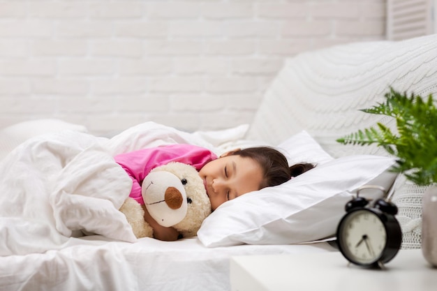 Cute little child girl sleeping with teddy bear