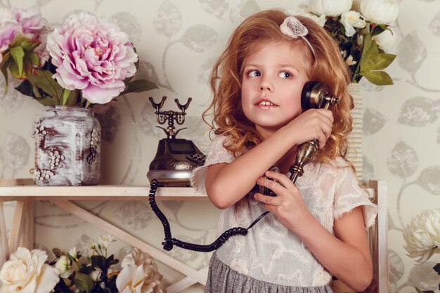 Ragazza carina bambino piccolo con fiori di primavera, bambina felice con cesto di fiori.