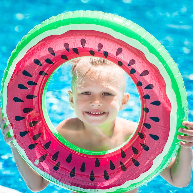 Foto piccolo bambino sveglio in piscina. nuoto divertente del bambino.