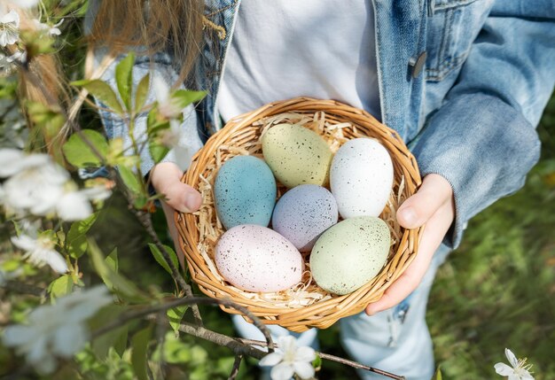 Cute little child wearing bunny ears on easter day girl holding basket with painted eggs