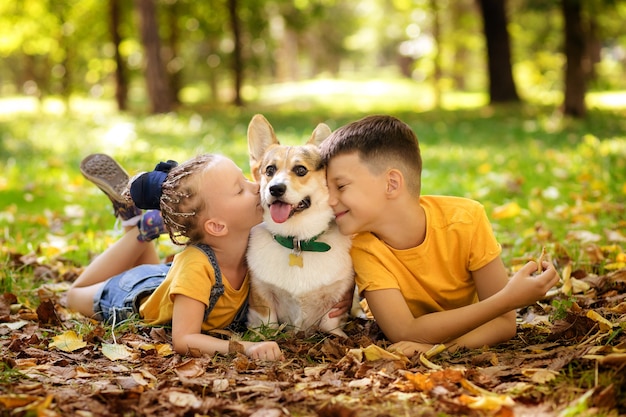 Photo cute little children with a dog in the park