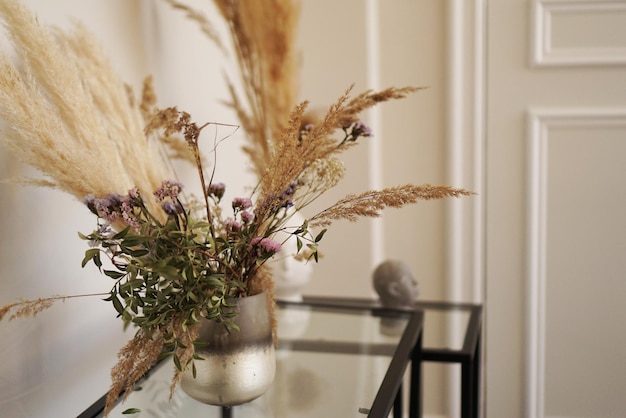 Cute little dried flowers in small glass vase in the living room.