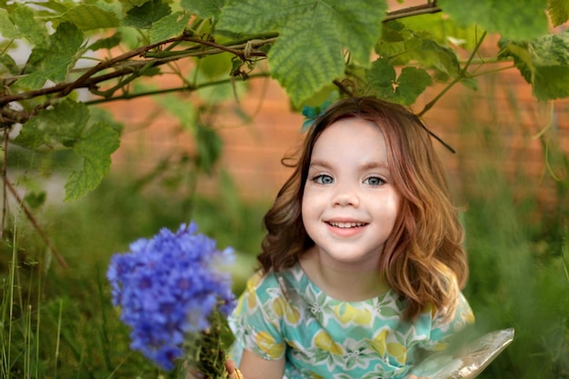 Cute little girl in autumn park holding bunch of yellow leaves