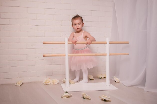 Foto bambina sveglia ballerina e il suo insegnante che fanno esercizi in classe di danza classica