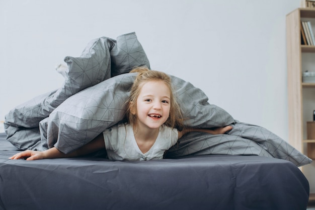 Foto bambina sveglia sul letto a casa