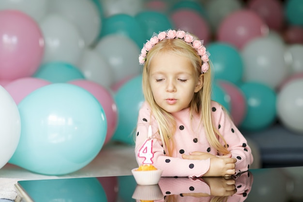 Милая маленькая девочка выдува свечи на день рождения